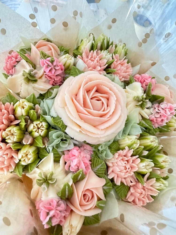 7 Deluxe cupcake bouquet with a blush rose centrepiece surrounded by pink and sage buttercream flowers