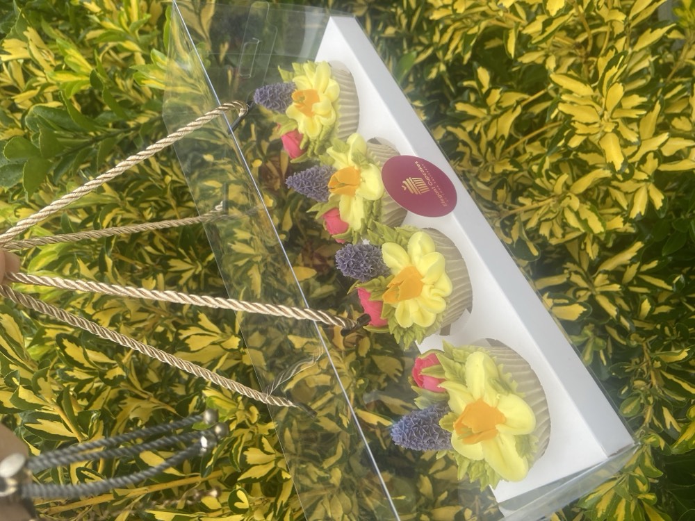 Gift box of yellow buttercream daffodil and hyacinth cupcakes