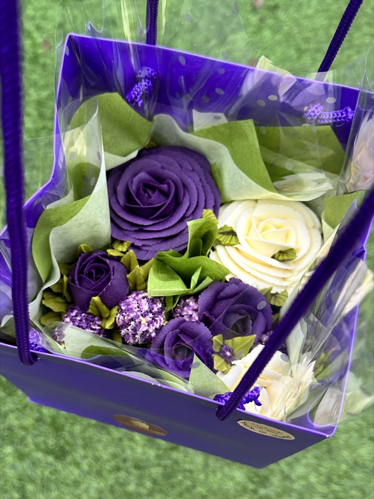 Purple gift bag with deep purple and ivory buttercream rose cupcakes