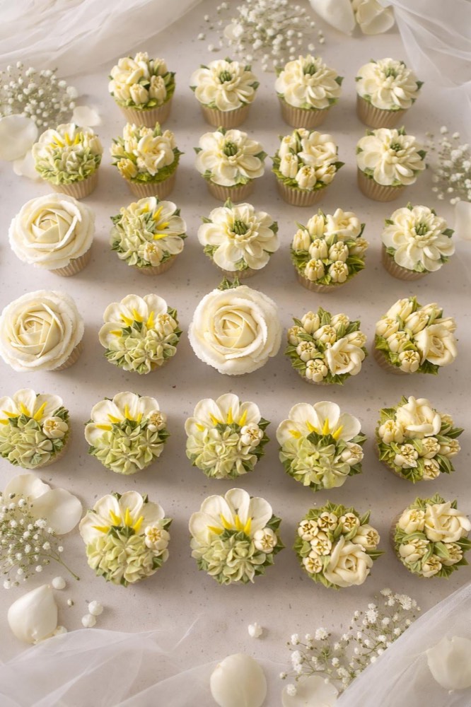 Flat lay grid of ivory buttercream rose and dahlia cupcakes with baby's breath