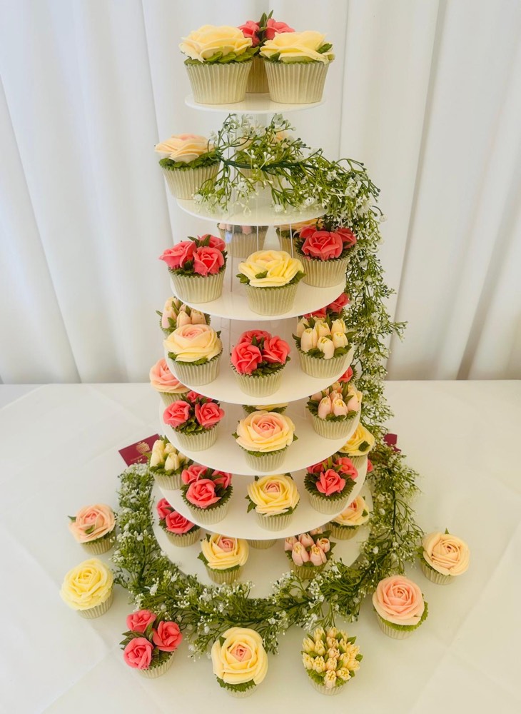 Seven-tier wedding cupcake tower with peach, coral and cream buttercream roses